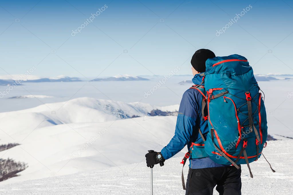 Traveler with backpack and winter mountain panorama