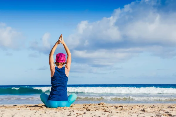 Mujer joven practicando yoga en la playa para zen, salud y guisante — Foto de Stock