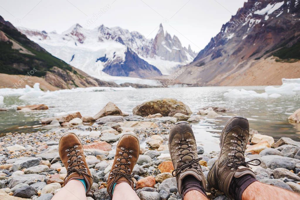 Travel trekking leisure holiday concept. Couple in hiking boots having fun and enjoying wonderful breathtaking mountain view