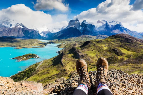 Bacaklar seyahat seyahat yüksek dağın tepesinde oturuyor. Özgürlük kavramı. Los Cuernos kayalar, Patagonia, Şili