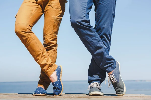 Piernas de joven abrazando pareja en la playa turquesa — Foto de Stock