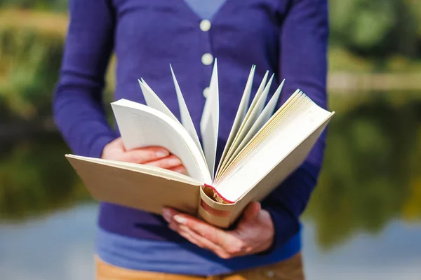 Primer plano de las manos femeninas sosteniendo el libro abierto. Concepto de lectura — Foto de Stock