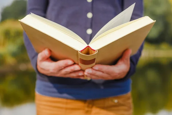 Close-up of female hands holding open book. Reading concept