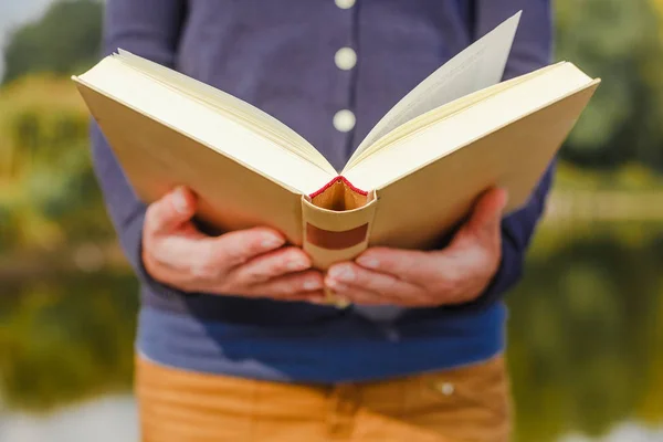 Primer plano de las manos femeninas sosteniendo el libro abierto. Concepto de lectura — Foto de Stock