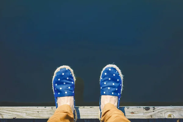 Woman on the pier takes a step into the water, from above — Stock Photo, Image