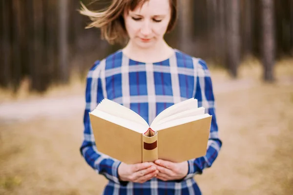 Joven estudiante sosteniendo libro al aire libre — Foto de Stock