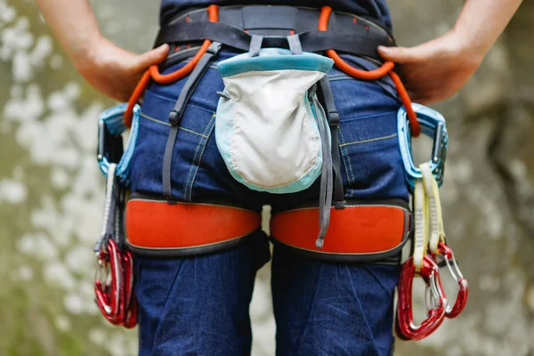 Female Climber with climbing equipment on the belt is ready to make her way up. Extreme sport — Stock Photo, Image