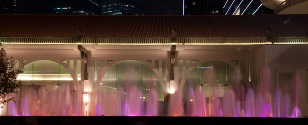 작은 물 분수 싱가포르 식민지 건물 앞 밤에 스톡 사진