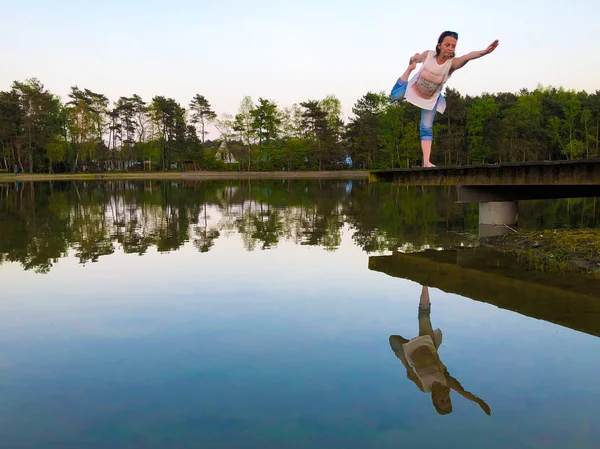 Una atractiva joven haciendo el arco de pie tirando de la pose de yoga — Foto de Stock