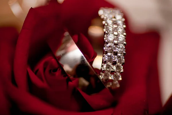 Anillos de boda sobre fondo de rosas rojas — Foto de Stock