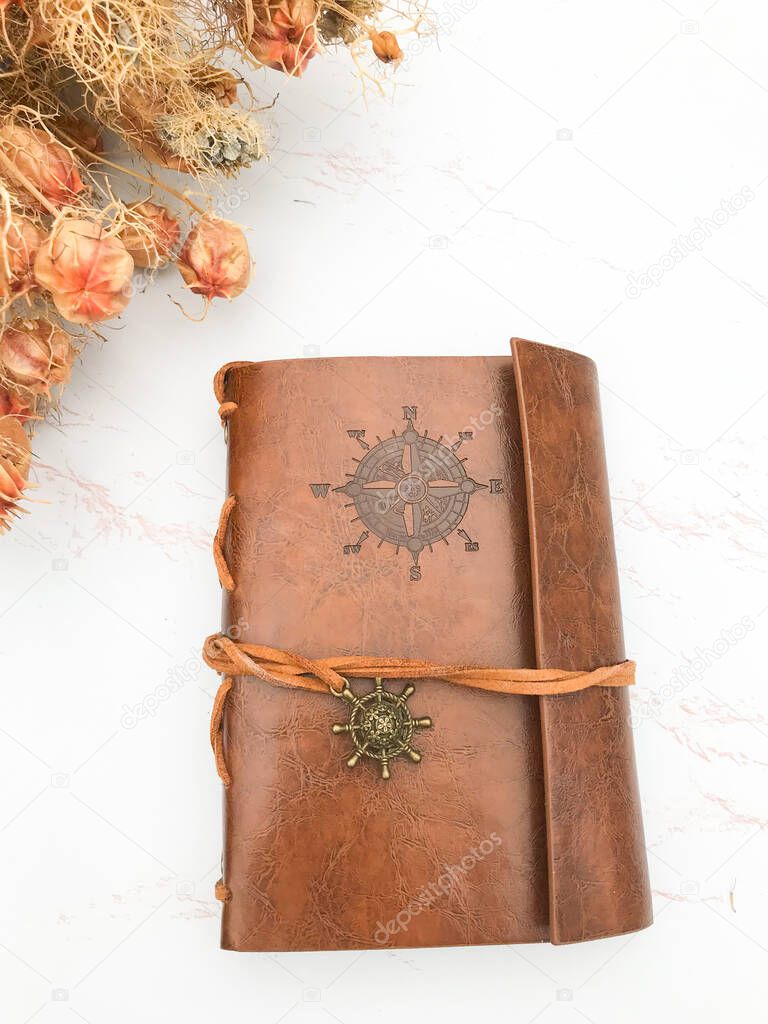 Dried flowers and a leather notebook
