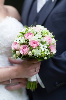 Kırmızı gül buketiyle tanınmayan gelin ve damat