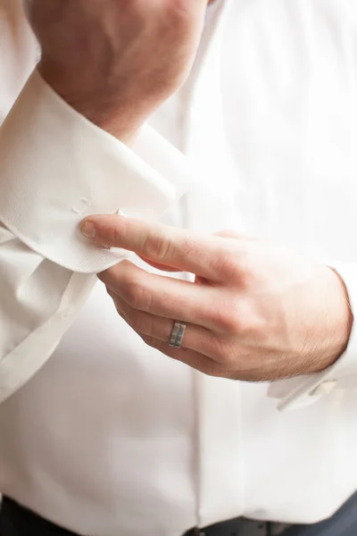 Primo piano di un uomo in smoking che si fissa il gemello sul vestito . — Foto Stock