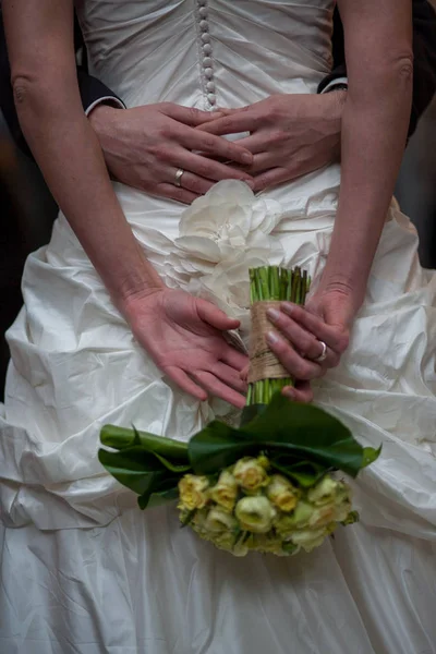 Неузнаваемые жених и невеста со свадебным букетом из красных роз — стоковое фото