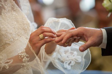 Gelin ve damat evlilik yüzüklerini değiş tokuş ediyor.