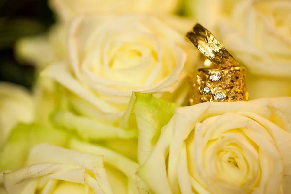 Anéis de casamento em rosas brancas fundo — Fotografia de Stock