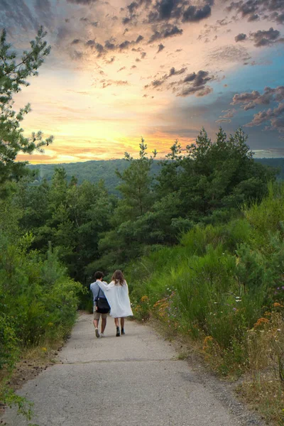 Una pareja amorosa caminando por un camino de tierra en el bosque — Foto de Stock