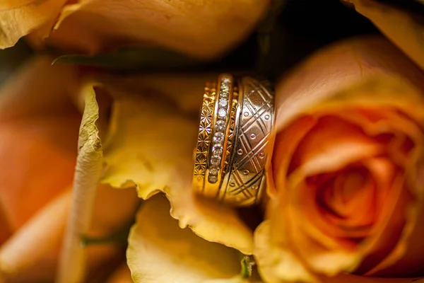 Anéis de casamento em rosas rosa fundo — Fotografia de Stock