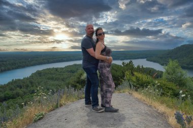 Mutlu çift dramatik bir günbatımına sarılıyor.