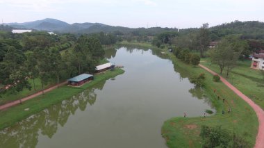 Malezya 'da müstakil evleri, kapalı mahalleleri ve evlerin önündeki bahçeleri olan bir banliyö yerleşiminin havadan görüntüsü.
