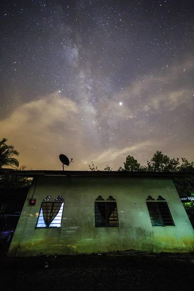 天の川銀河と真夜中に1つの小さな家の上に星 — ストック写真