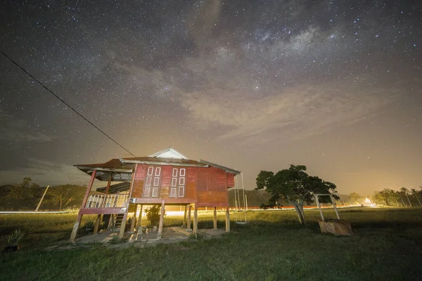 Milky Way Galaxy and stars over one small house at mid Night.