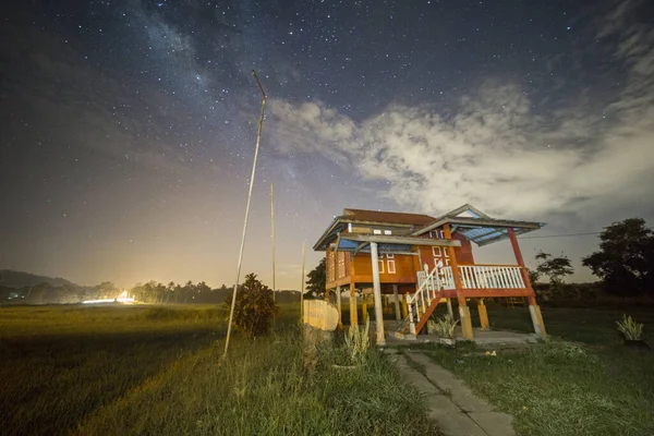 Milky Way Galaxy and stars over one small house at mid Night.