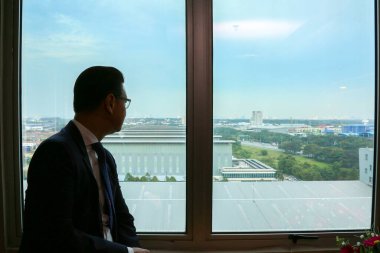 17 Dec 2018; Shah Alam Selangor Malaysia : Businessman looking outside the window of PKT Logistic warehouse Shah Alam Selangor.
