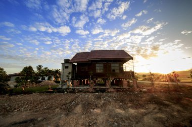 Geleneksel Malay evi, tarlanın kenarında, mavi gökyüzü ile birlikte.