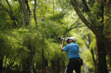 Ormanda dürbünlü genç bir kadın.