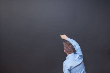 bir şey siyah arka plan üzerine açıklayan mavi tişörtlü adam