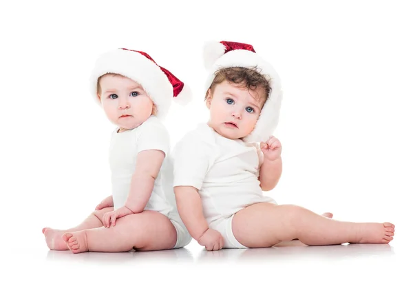 Bebês bonitos em chapéus de Papai Noel — Fotografia de Stock