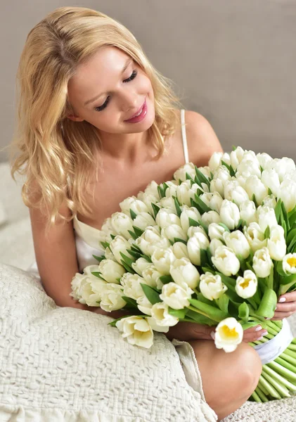 Schöne junge blonde Frau mit Tulpenstrauß — Stockfoto