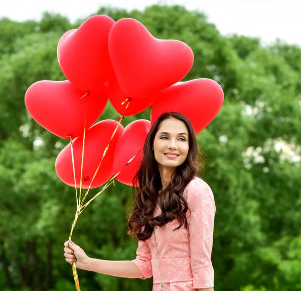 Femme avec ballons coeur rouge — Photo