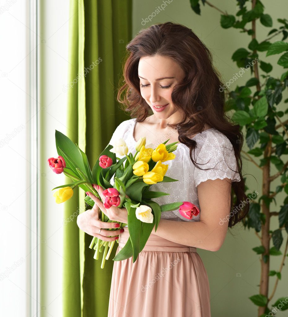 Beautiful young woman with tulip bouquet
