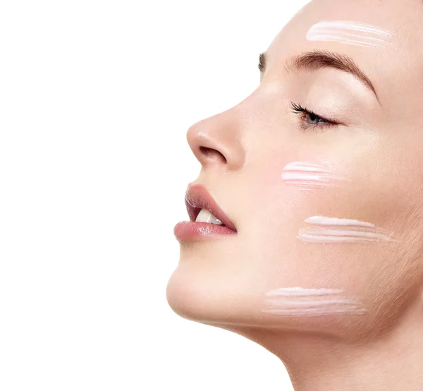 Mujer aplicando crema hidratante facial — Foto de Stock