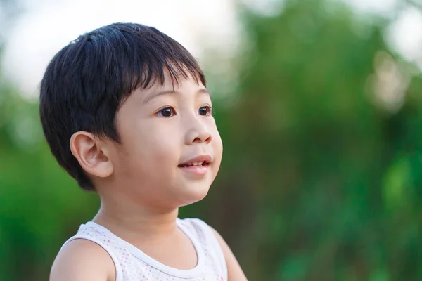 Der Junge lächelte im Garten — Stockfoto