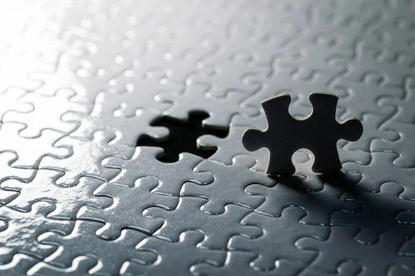 Jigsaw puzzle is a two-piece black silhouette. On the background