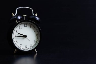 Siyah arkaplan detayındaki eski siyah alarmlı saat yakın plan nesnesi