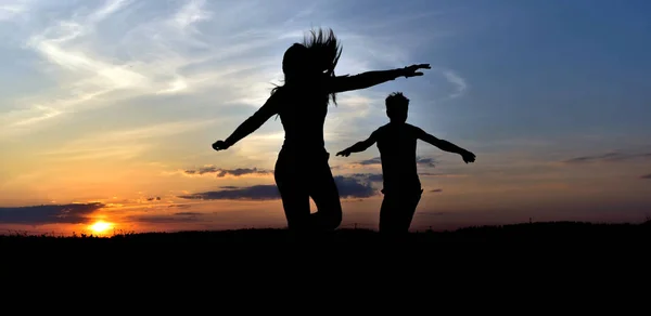 Boy and girl at sunset — Stock Photo, Image
