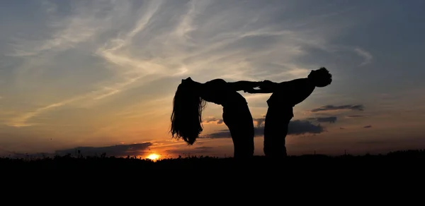 Boy and girl at sunset — Stock Photo, Image