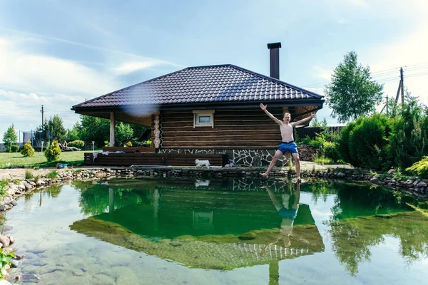 O menino salta para o woter no verão tne — Fotografia de Stock