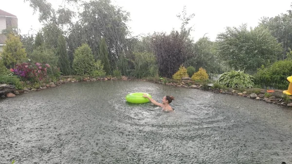 水の中の女の子が雨の中で泳ぐ — ストック写真