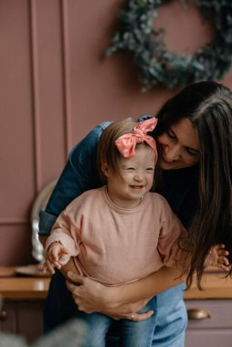 Annenin sevgisi ve bakımı. Down Sendromlu kız. Çocuklar için sevgi kavramı