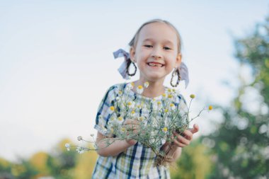 Dışarıda çiçekleri olan sevimli bir kız