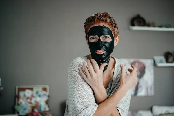 Girl in a black mask. Skin care. Cosmetology
