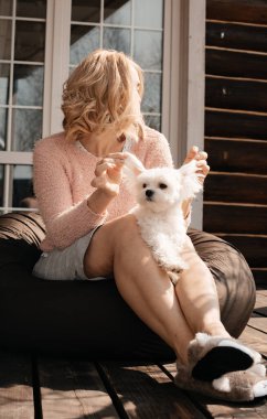 Verandada oturan köpekli çekici bir kadın.