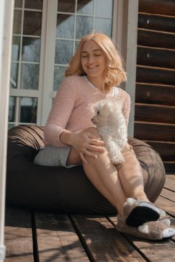 Verandada oturan köpekli çekici bir kadın.