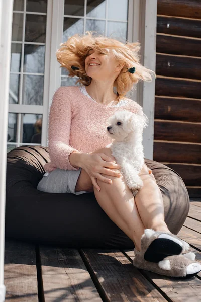 attractive woman with dog sitting on patio