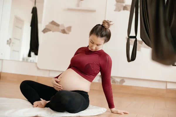 Hamile Bir Kadın Stüdyoda Yoga Yapıyor Sıkı Vücut Giyiyor Balyasını — Stok fotoğraf